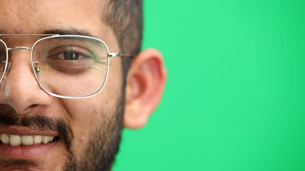 Man's face, on a green background, close-up.