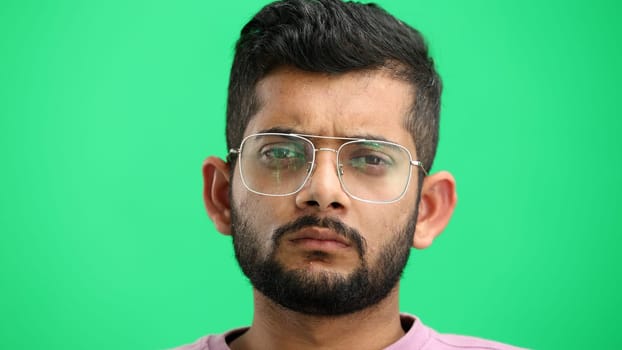Man's face, on a green background, close-up.