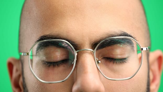 Man's face, on a green background, close-up.