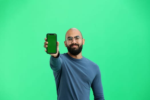 Man, on a green background, close-up, with a phone.