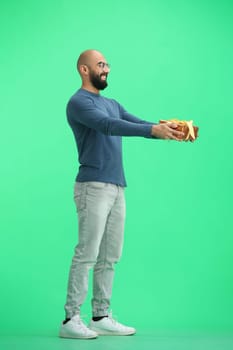 A man, on a green background, in full height, with a gift.