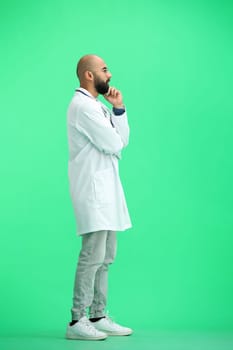 A male doctor, on a green background, in full height, thinks.