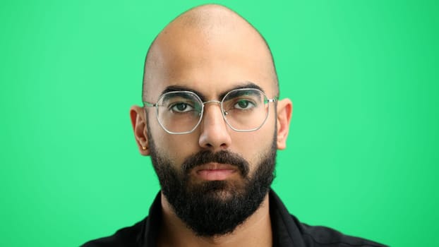 Man's face, on a green background, close-up.