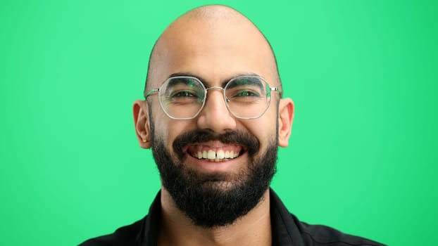 Man's face, on a green background, close-up.