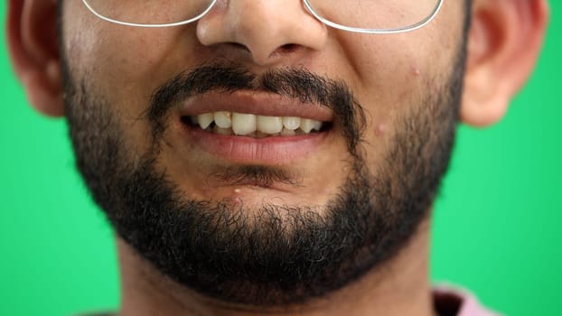 Man's face, on a green background, close-up.