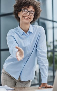 businesswoman offering handshake, standing with extended hand in office