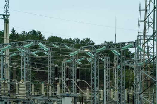 High voltage towers with sky background. Power line support with wires for electricity transmission. High voltage grid tower with wire cable at distribution station. Energy industry, energy saving.