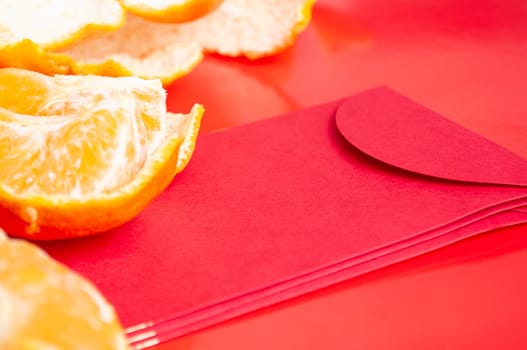 Peal Mandarin oranges and Chinese New Year red packet. Chinese New Year celebration concept.