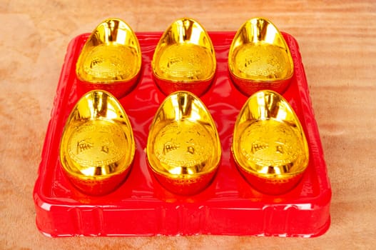 Golden ingots on wooden table. Wealth and abundance concept