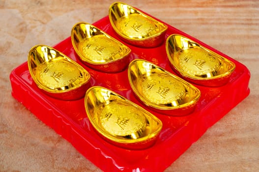 Golden ingots on wooden table. Wealth and abundance concept.