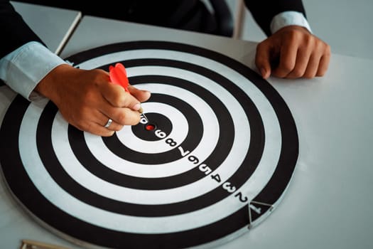 Businessman leader aiming at mission target. Concept of challenge in business marketing bullseye and intelligent customer reach. dart is strategy or skill. dartboard is project goal. uds