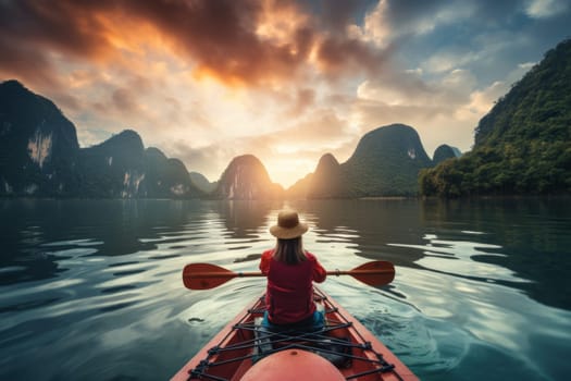 Rear view of woman riding kayak in stream with background of beautiful landscape.