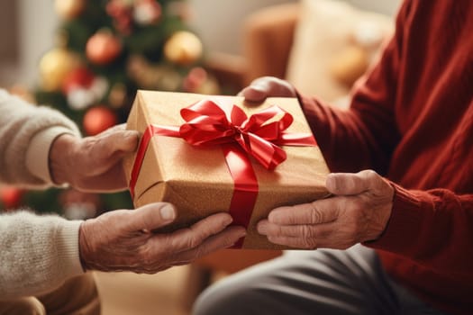 Hands of parent giving Christmas gift on Christmas tree background.