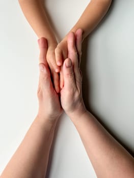 Mothers hands holding childs hands on white background. High quality photo