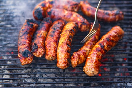 Grilling sausages on barbecue grill. Delicious sausages on charcoal grill