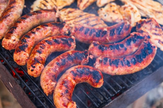 Grilling sausages and pork chops on barbecue grill. BBQ in the garden