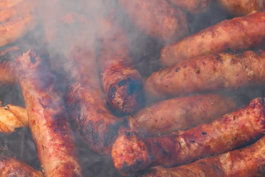 Close up on details of homemade sausages on barbecue grill. Barbecue, grill and food concept.