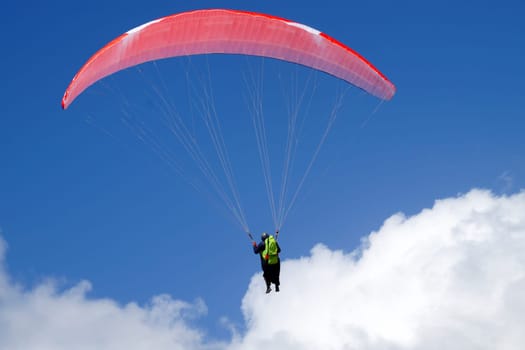 man flying on a parachute wing with a blue sky close-up
