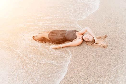 Woman travel sea. Young Happy woman in a long red dress posing on a beach near the sea on background of volcanic rocks, like in Iceland, sharing travel adventure journey