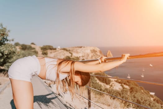 Fitness woman sea. Outdoor workout on yoga mat in park near to ocean beach. Female fitness pilates yoga routine concept. Healthy lifestyle. Happy fit woman exercising with rubber band in park.