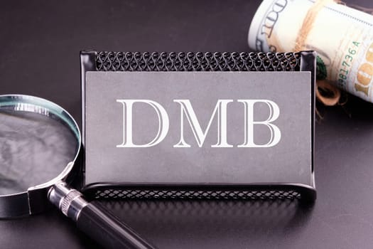 DMB text on the business card next to the money, a magnifying glass on a black background