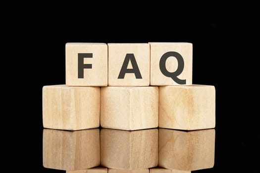 FAQ TEXT text assembled from wooden cubes on a black background