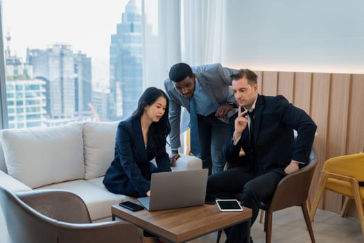 Diverse business team looking at laptop while discussing about business idea. Group of happy manager talking , thinking sharing business strategy while young businesswoman using laptop. Ornamented.