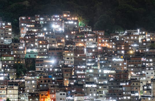 A densely built favela hill glowing under night lights