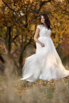 beautiful sensual bride in white wedding dress standing outdoor on natural background