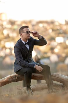 Handsome young man in classic checked suit and sunglasses outdoor