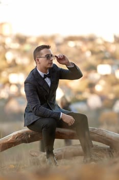 Handsome young man in classic checked suit and sunglasses outdoor