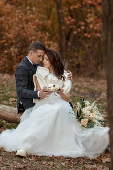 bride and groom on the nature in autumn . wedding couple with cake outdoor