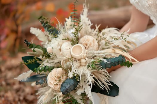 hands of the bride holding beautiful autumn bouquet outdoor