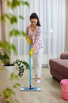 woman cleaning and mopping floor at living room, daily housekeeping