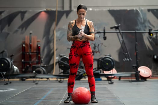 Strong woman ready to use a medicinal ball in a cross training gym