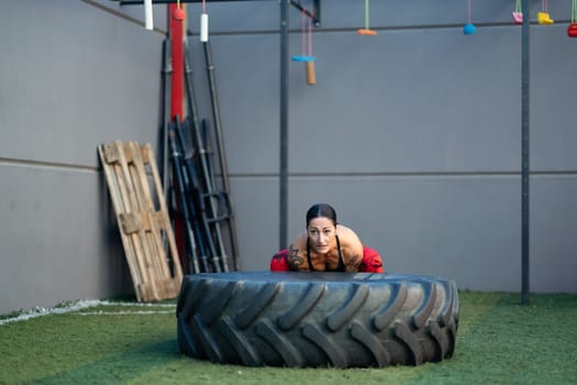 Horizontal photo with copy space of a strong woman working out with a wheel in a gym