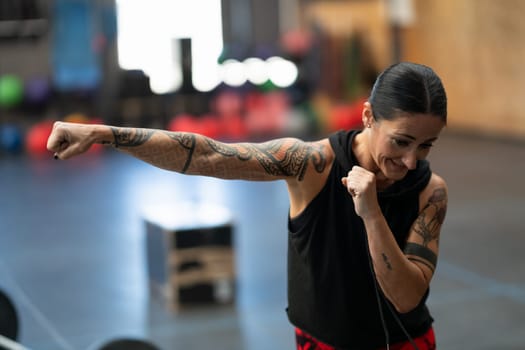 Close-up of a mature sportive woman practicing shadowboxing in a gym