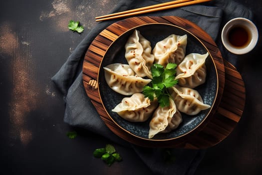 Steamed dumplings on a round plate with dipping sauce and chopsticks