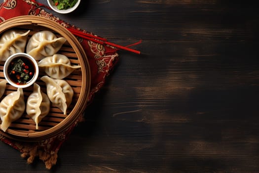 Steamed dumplings in bamboo steamer with dipping sauce on the side