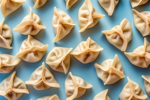 Arranged dumplings on blue background, poised for cooking.