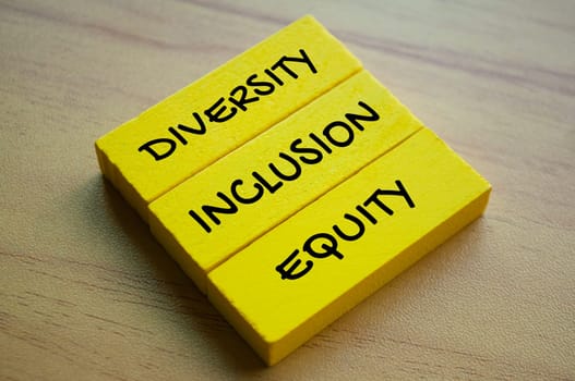 Diversity, inclusion and equity text on yellow wooden blocks. Diversity concept.
