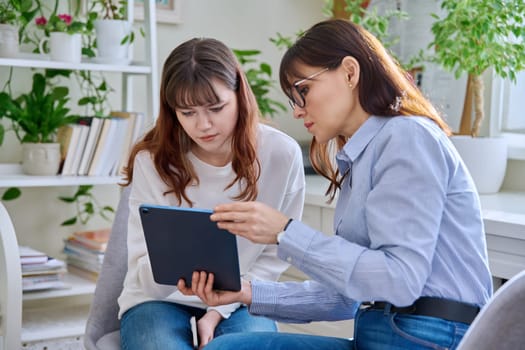 Teenage girl college student at therapy meeting with mental health professional social worker psychologist counselor sitting together in office. Psychologists, psychotherapy, mental assistance support