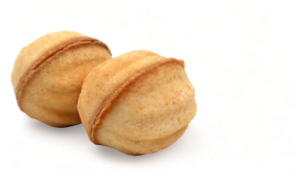 Two fresh and tasty cookies in the shape of a walnut with boiled condensed milk on a white background. A favorite delicacy for children and adults with a delicate filling inside