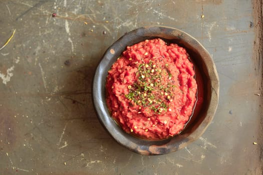 Harissa sauce, traditional in the Maghreb countries, made from hot red pepper, garlic and spices in a bowl on the surface of a natural stone.Top view.