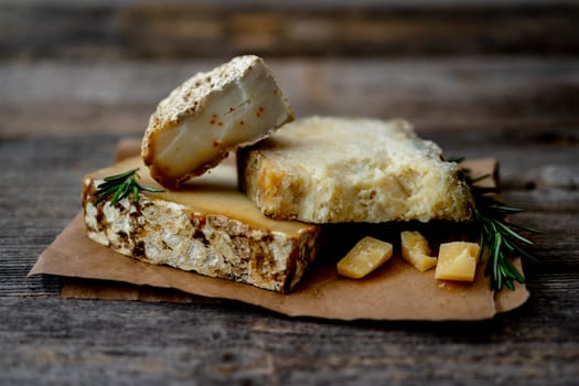 Homemade Goat Cheese On Craft Paper Rests On An Old Rustic Table