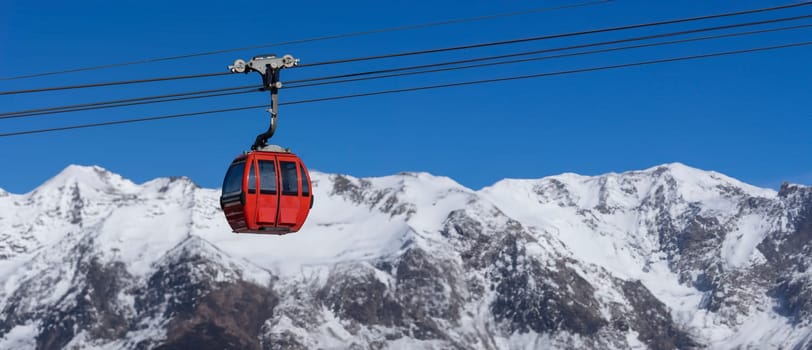 A bright red cable car dangles above the pristine snow, offering a striking pop of color against the vast white mountains and clear blue sky. This image captures the essence of alpine adventure, ascending towards the peak for a breathtaking view