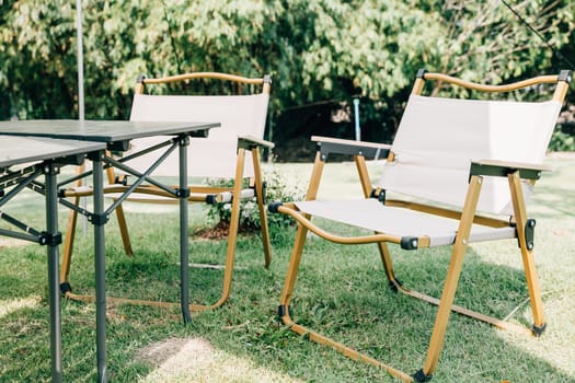 Enjoy a picnic in the great outdoors with an outdoor camping tent shelter, tables, and chairs. This suburban relaxation setup in the summer provides a comfortable and shaded spot for your picnic.