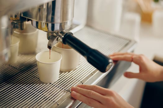Close up of barista use coffee machine filling a two cups with espresso in professional coffee shop