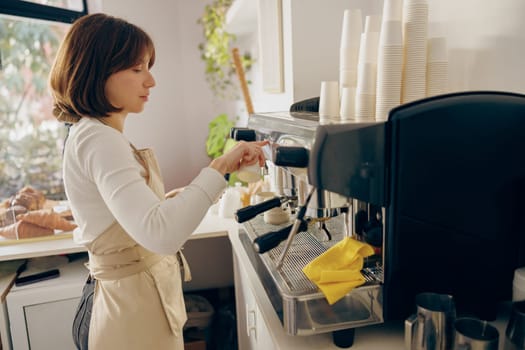 Professional female barista making coffee in a coffee machine working in cafe. High quality photo