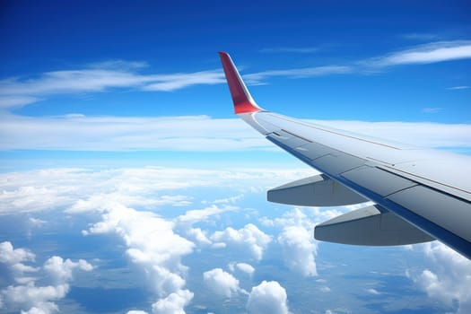 Photo View from the window of an airplane wing while flying over a blue sky.